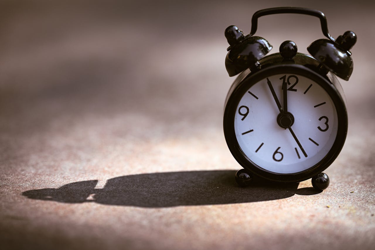 Crafting Captivating Headlines: Your awesome post title goes here A classic black alarm clock showing five minutes to twelve on a textured surface with dramatic shadow.